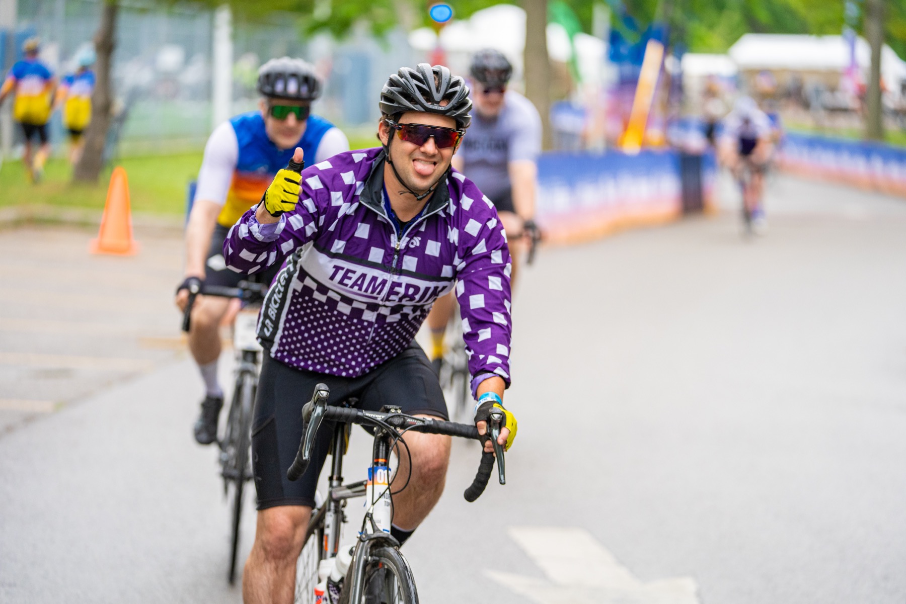 A smiling cyclist in a purple Team Erin jersey