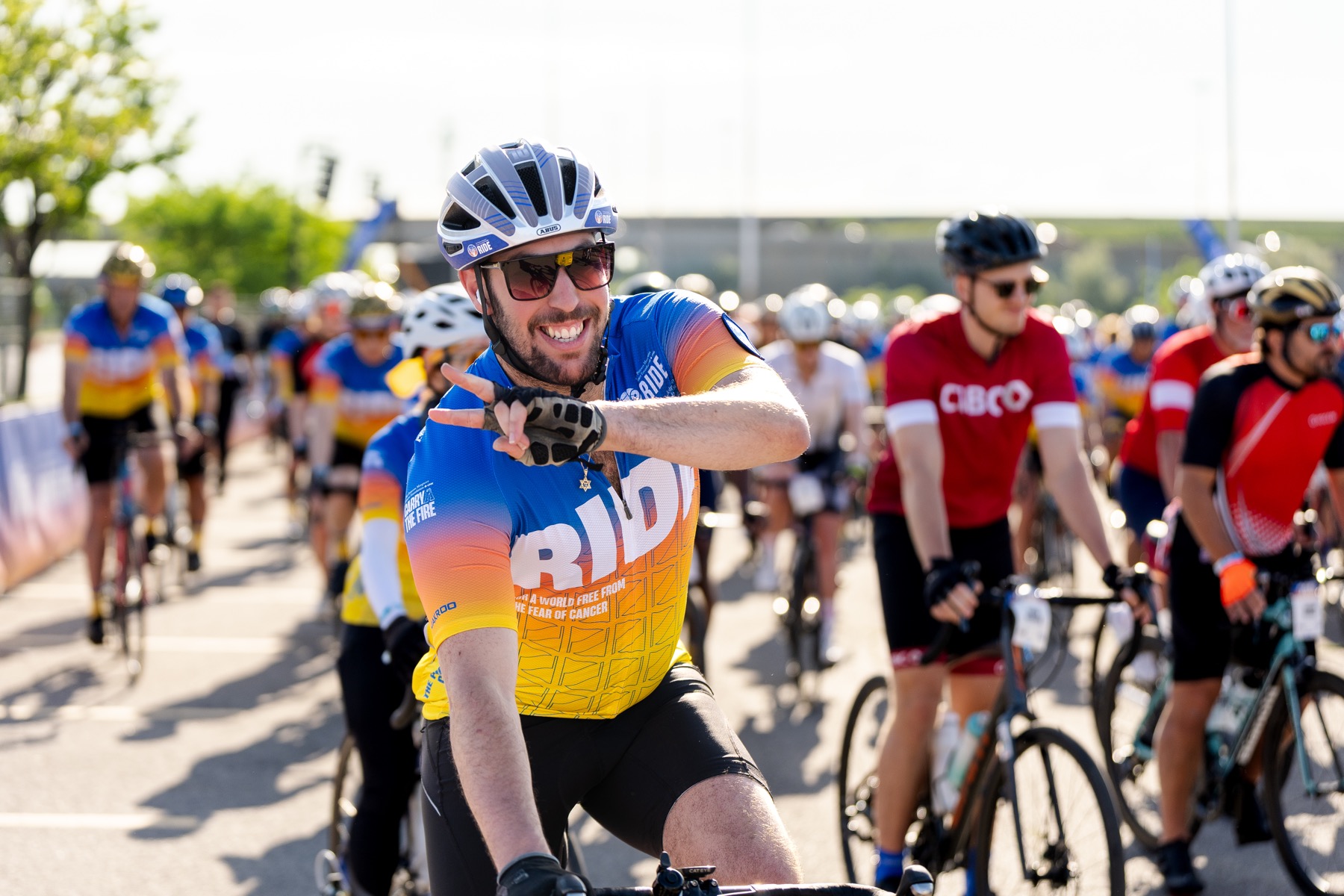 A smiling rider gives a peace sign at the 2026 Ride