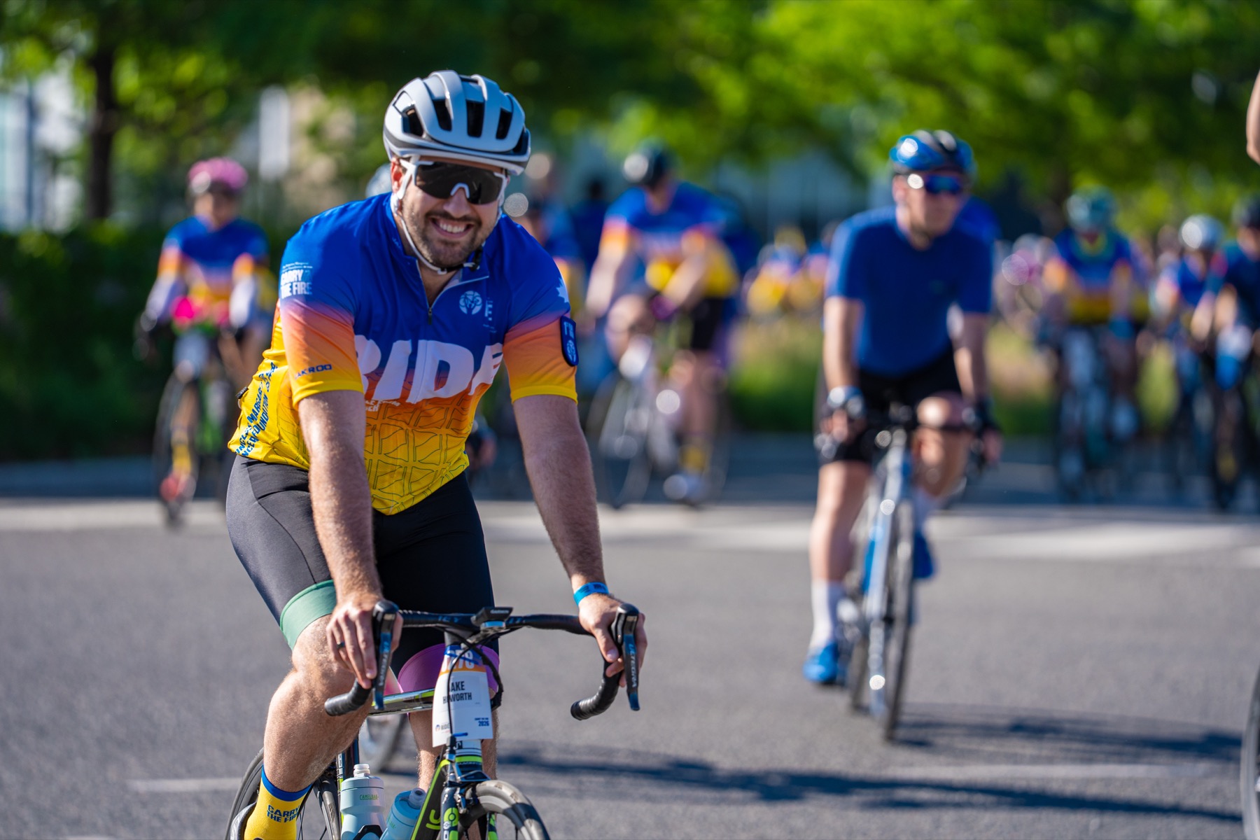 A smiling cyclist riding with the team at the 2026 Ride