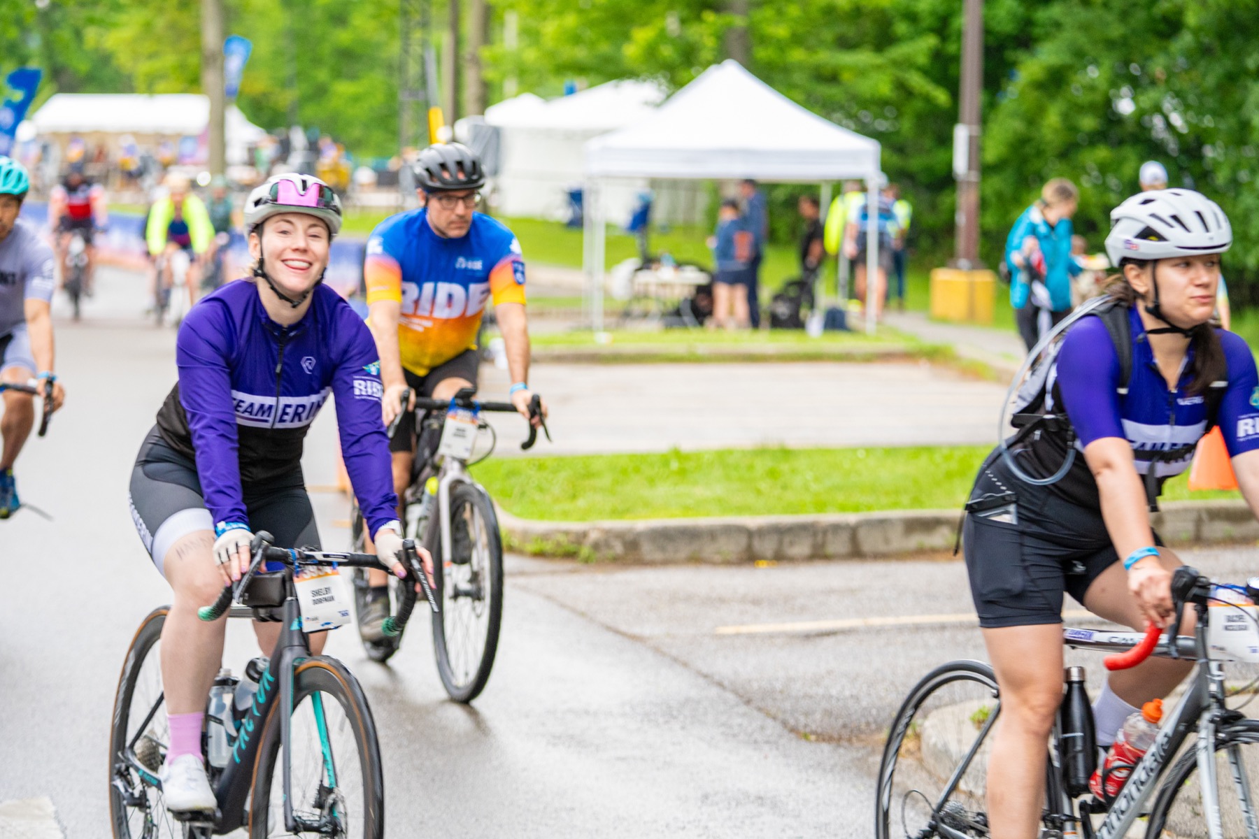 A smiling Team Erin rider cycling with the team in 2026